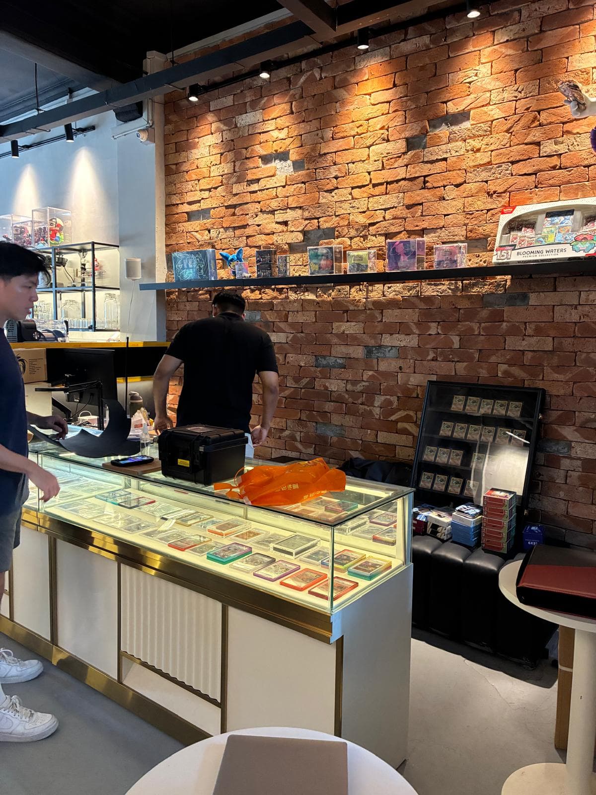 Trading cards displayed in KAISH’s glass counter against the brick wall